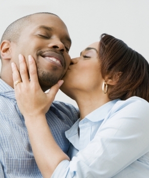 African American man enjoying the affection of his wife