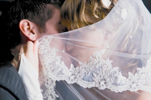 veiled wedding kiss
